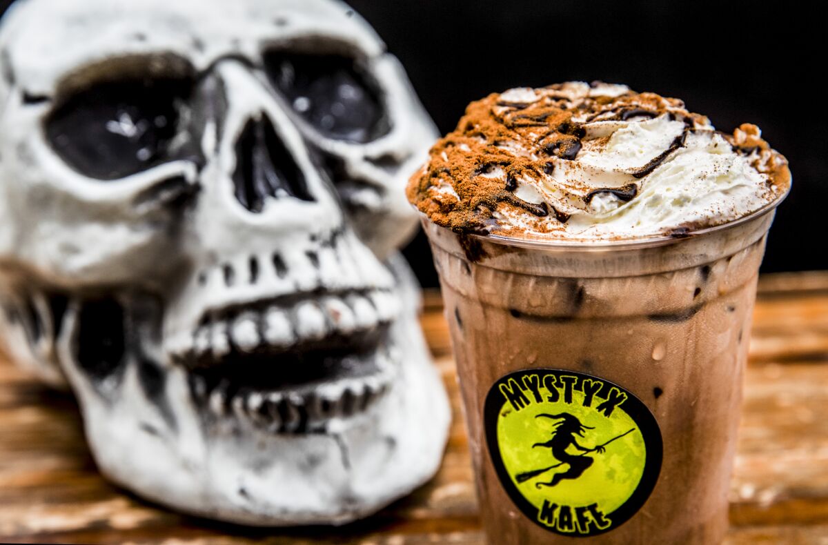 A skull sits next to a mocha drink.