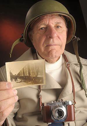 World War II veteran Donald Burdick, of Forks Township, Pa., holds a photograph he took during the liberation of Dachau concentration camp.
