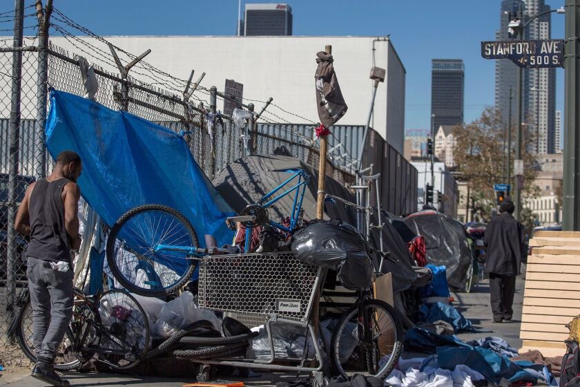 The homeless gather around tents along 5th Street and Stanford Avenue on skid row in Los Angeles this month.