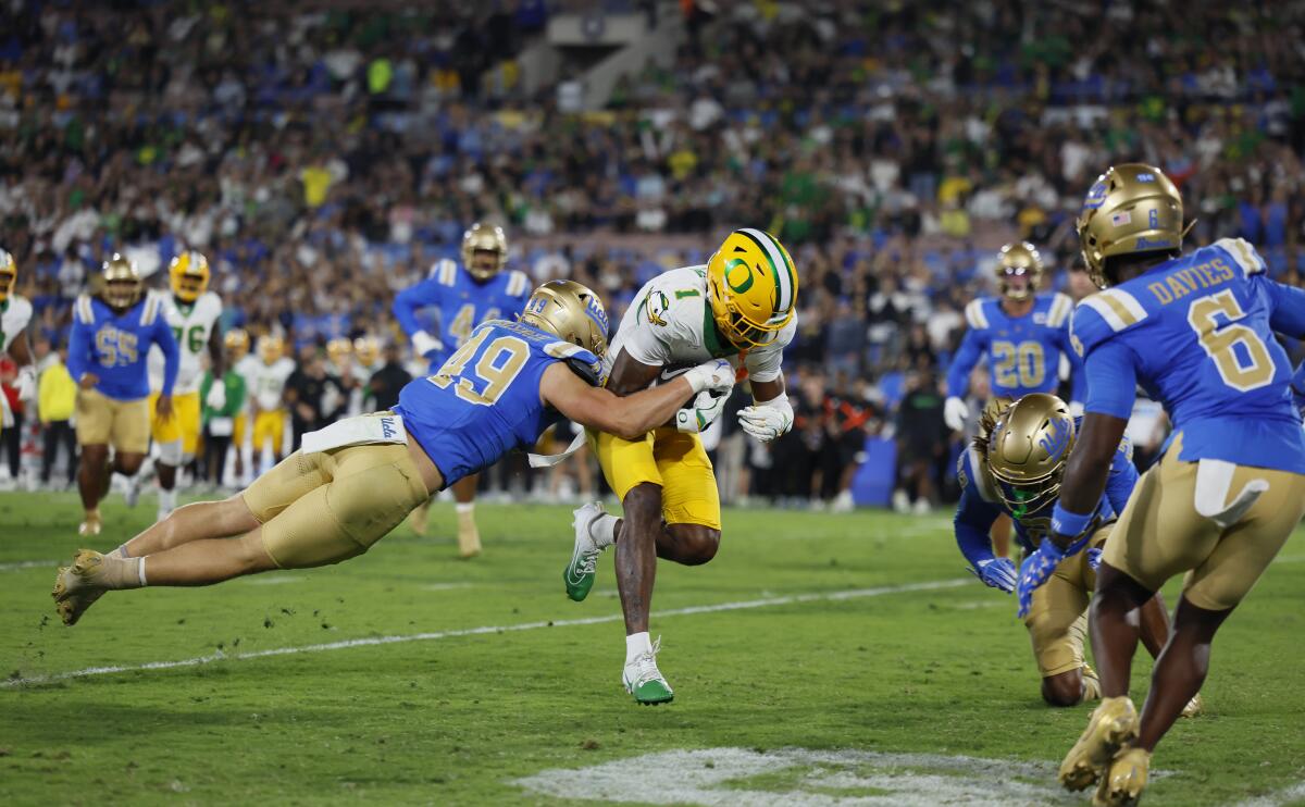UCLA coach DeShaun Foster says efficiency coach apologized to crew after penalty 1 UCLA linebacker Carson Schwesinger leaps to Oregon wide receiver Traeshon Holden as he runs in a touchdown on Sept. 28.