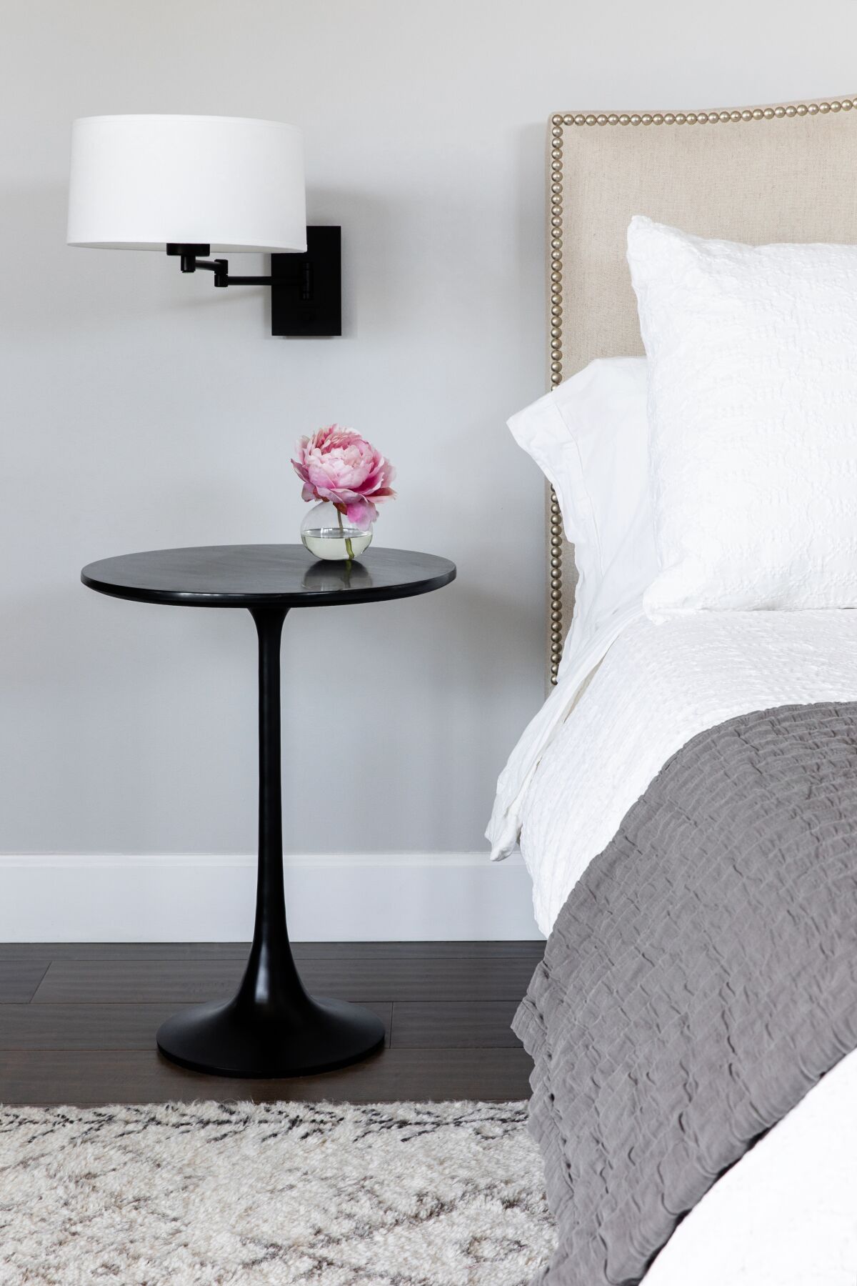 A little side table by the bed offers a space for simple pleasures: a small vase, or a cup of tea.