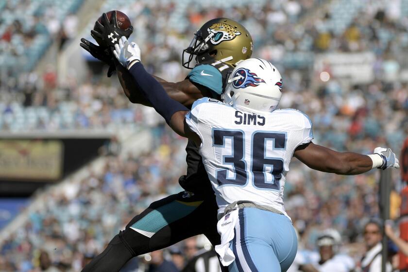 Jaguars receiver Marqise Lee catches a pass in front of Titans cornerback LeShaun Sims for a touchdown during the first half of their game Dec. 24.