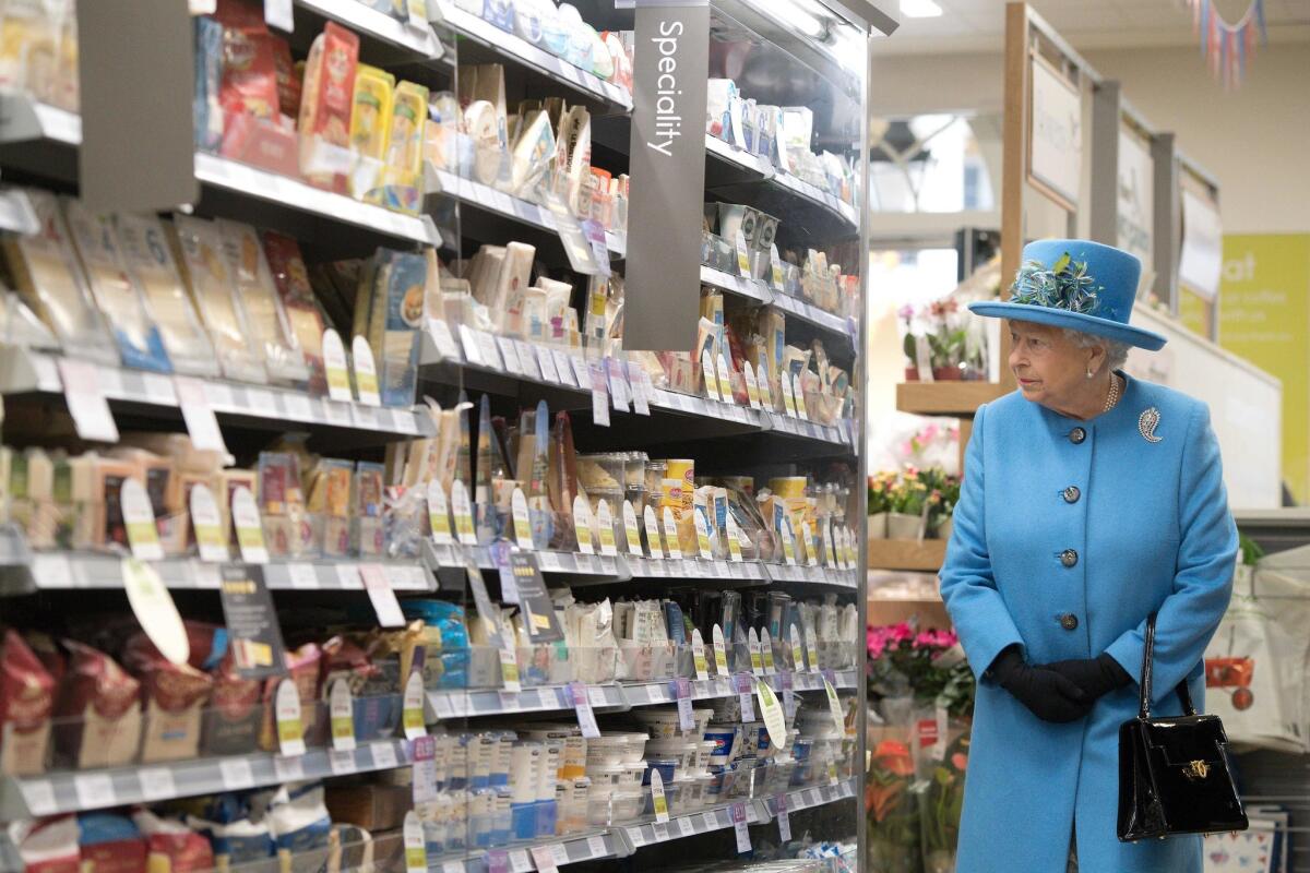 The Queen pauses to review the cheese selection at the Waitrose.