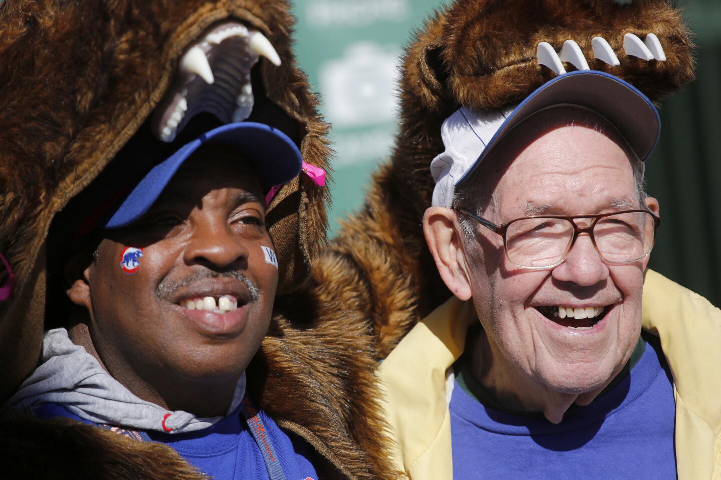 Streetwise vendor Samuel Sanders, left, poses with Cubs fan Raymond Barnes, 85, under the marquee at Wrigley Field on Oct. 24, 2016, ahead of the World Series.