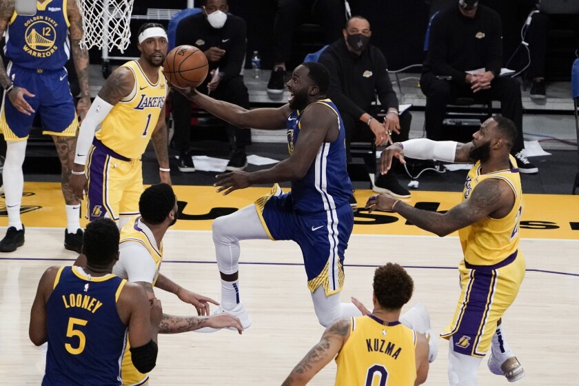 Warriors forward Draymond Green drives down the lane against the Lakers for a layup.