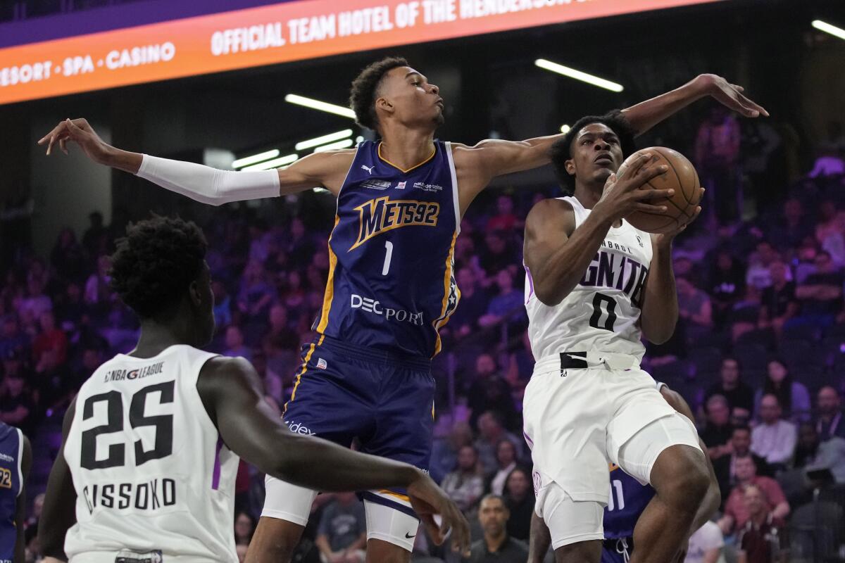 Boulogne-Levallois Metropolitans 92's Victor Wembanyama, center, guards NBA G League Ignite's Scoot Henderson, right, during the first half of an exhibition basketball game Tuesday, Oct. 4, 2022, in Henderson, Nev. (AP Photo/John Locher)