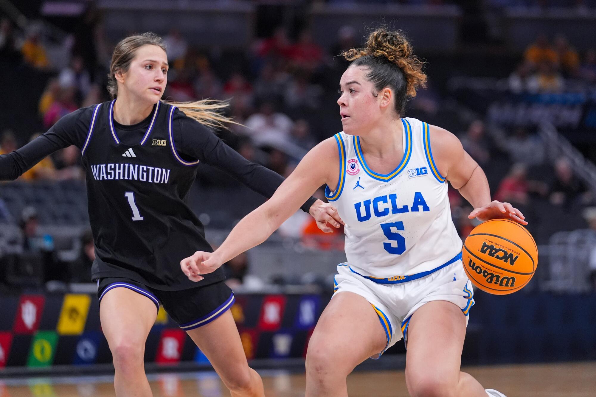 UCLA gardiyanı Charlisse Leger-Walker, Cuma günü Washington gardiyanı Hannah Stines'ın baskısı altında araba kullanıyor.