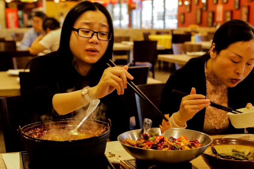ALHAMBRA, CA, DECEMBER 21, 2016: Cathy Ji, left facing, May Yu and friends having a pot of Boil Beef in chili sauce and a bowl of Trick Eggplant for lunch at Legendary Restaurant in Alhambra. (Irfan Khan / Los Angeles Times)