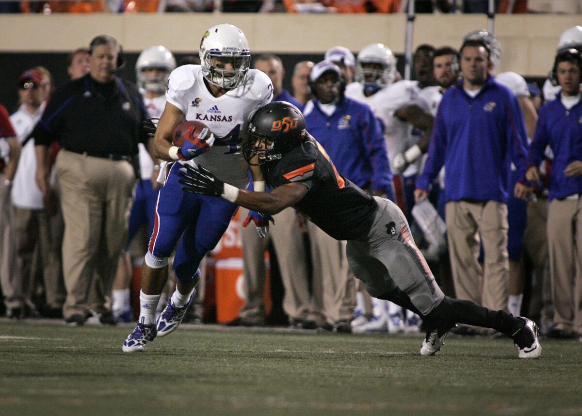 Kansas running back Connor Embree is hit by Oklahoma State safety Lyndell Johnson on Nov. 9, 2013, in Stillwater, Okla. Embree is now an assistant coach with the Kansas City Chiefs.