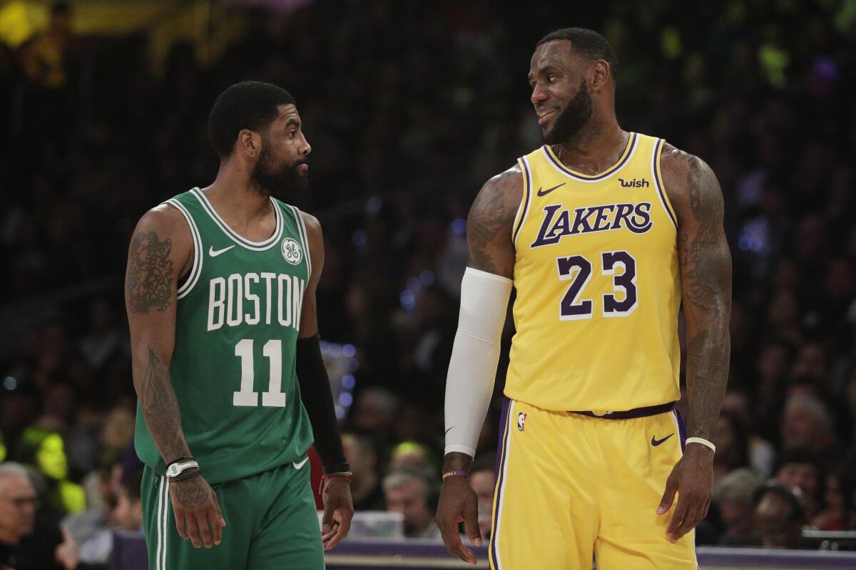 Lakers star LeBron James, right, chats with Boston's Kyrie Irving during a game in March 2019.