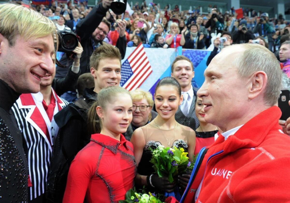 Russian President Vladimir Putin speaks to Yevgeny Plushenko, left, and other Russian Olympic figure skaters. Russia won gold in team figure skating.