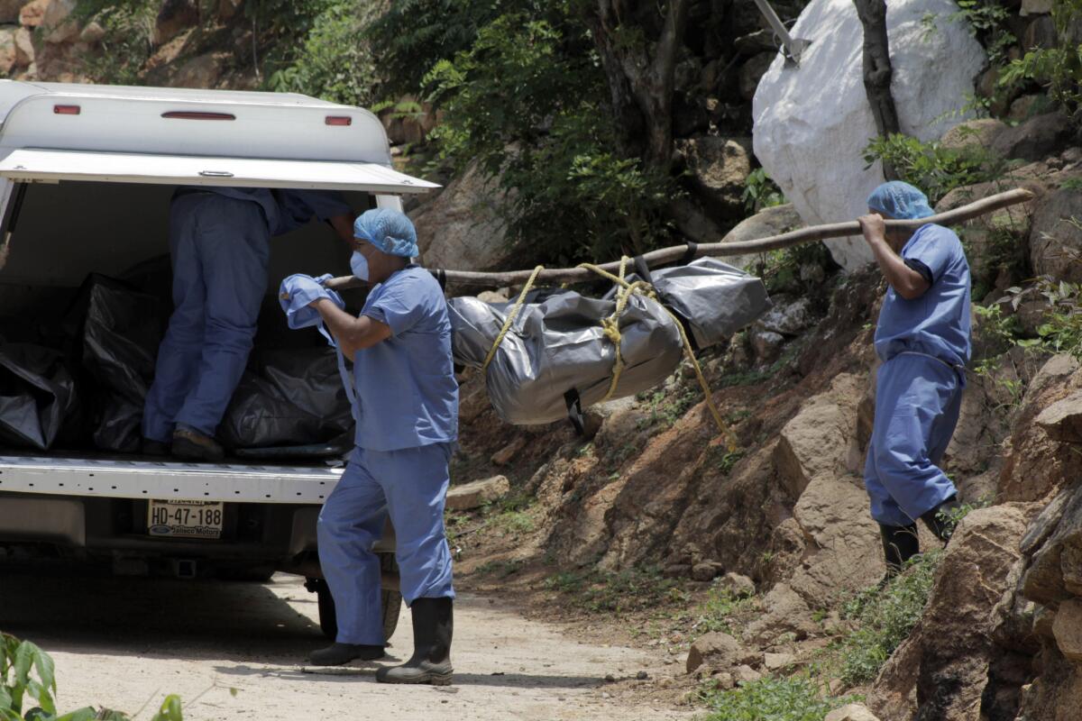 Forenses trasladan un cuerpo hasta una camioneta luego de hallar al menos 10 cadáveres en tumbas clandestinas a las afueras del centro vacacional de Acapulco. (Foto AP/Bernandino Hernandez)