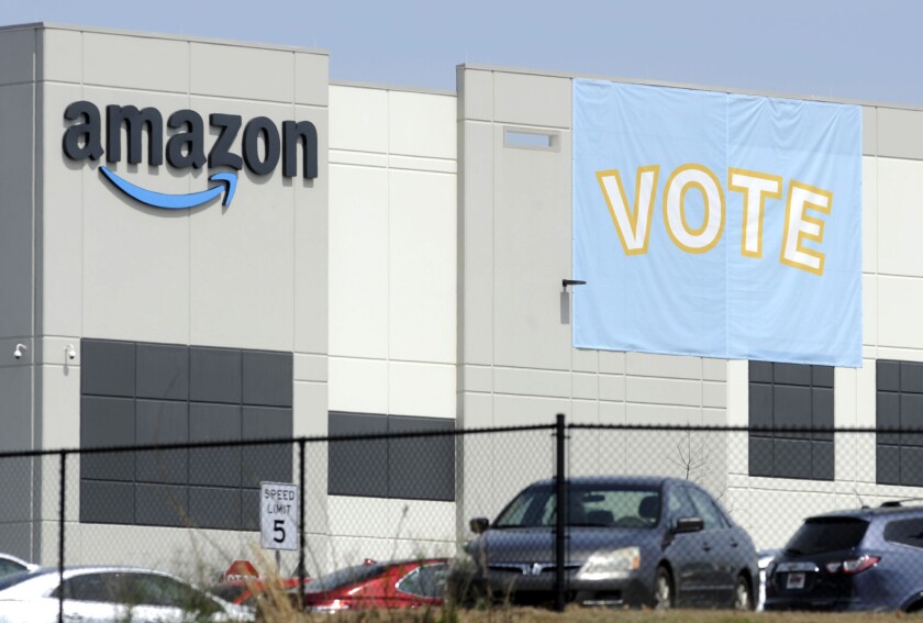 FILE - In this March 30, 2021 file photo, a banner encouraging workers to vote in labor balloting is shown at an Amazon warehouse in Bessemer, Ala. A labor official is confirming a new union election for Amazon workers in Bessemer, based on objections to the first vote in a rare move. The decision was first announced on Monday, Nov. 29, 2021 by the Retail, Wholesale and Department Store Union, which spearheaded the union organizing movement (AP Photo/Jay Reeves, File)