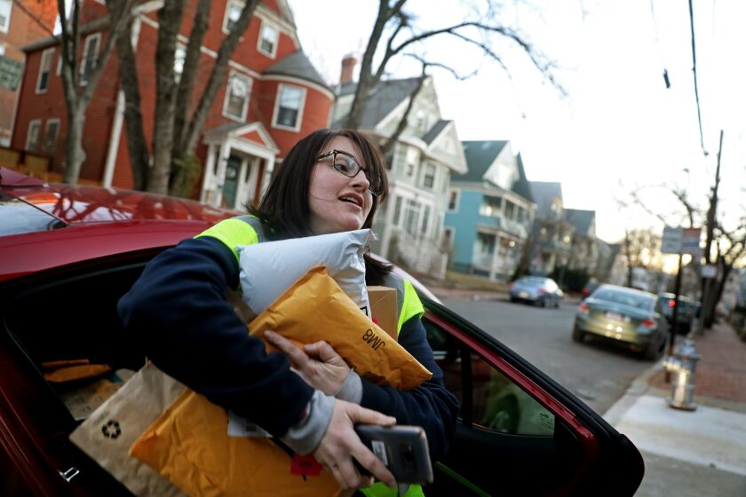 Amazon, already trying to keep up with a surge in online orders, depends on the willingness of tens of thousands of contract drivers to show up each day. Above, Amazon Flex driver Arielle McCain delivers packages in Cambridge, Mass., in 2018.