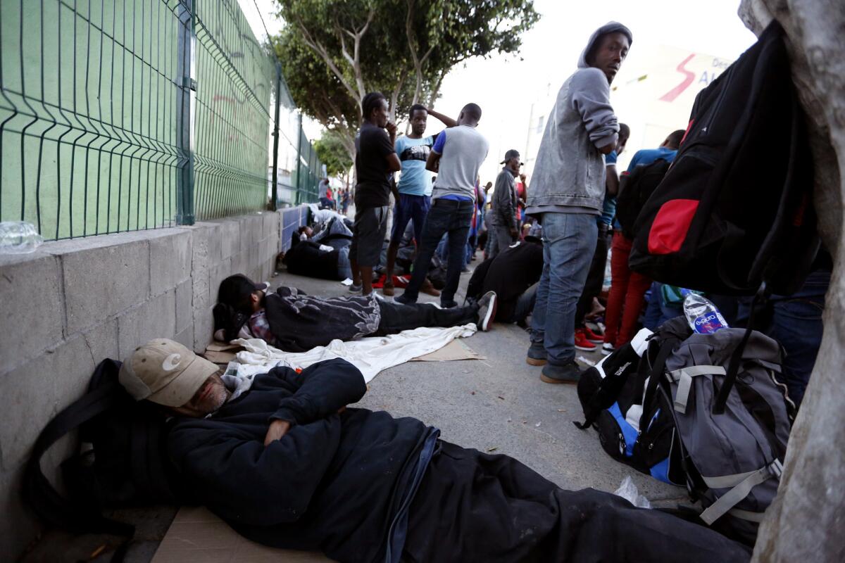 Migrants sleep in the street across from the Desayunador Salesiano Padre Chava shelter in Tijuana, Mexico.