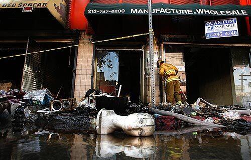 The foam head of a mannequin head lies in front of a garment district building at 11th and Los Angeles Streets in downtown Los Angeles after a fire destroyed the commercial building.