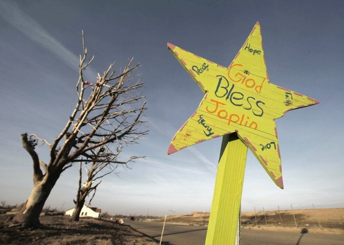 An inspirational sign at an intersection in a Joplin, Mo., neighborhood that was destroyed in May by a tornado.