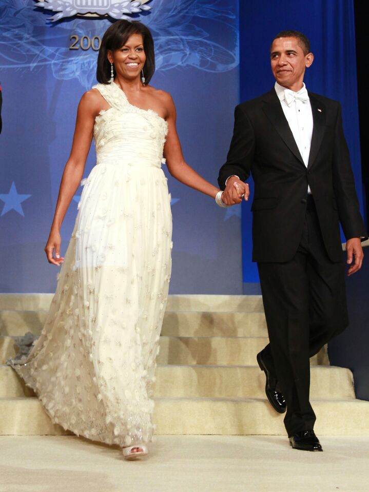 President Obama and First Lady Michelle Obama at the Obama Homes States Ball on Jan. 20, 2009. She's wearing a one-shouldered, white silk chiffon gown embellished with organza flowers with Swarovski crystal centers by Jason Wu. Rounding out the outfit were Jimmy Choo shoes and diamond earrings, bracelets, and a ring designed for her by Loree Rodkin.