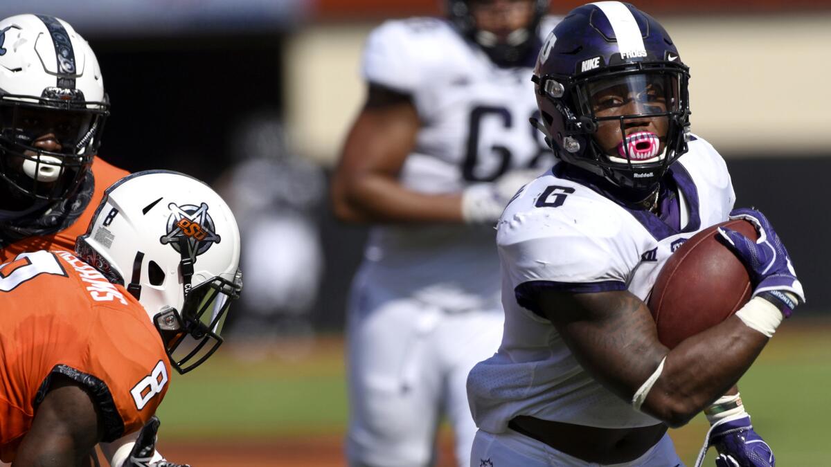 TCU running back Darius Anderson breaks past Oklahoma State defenders on a touchdown run in the first half Saturday.