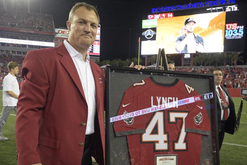Former Bucs safety John Lynch poses with his jersey during a ceremony inducting him in the team's Ring of Honor in 2016.
