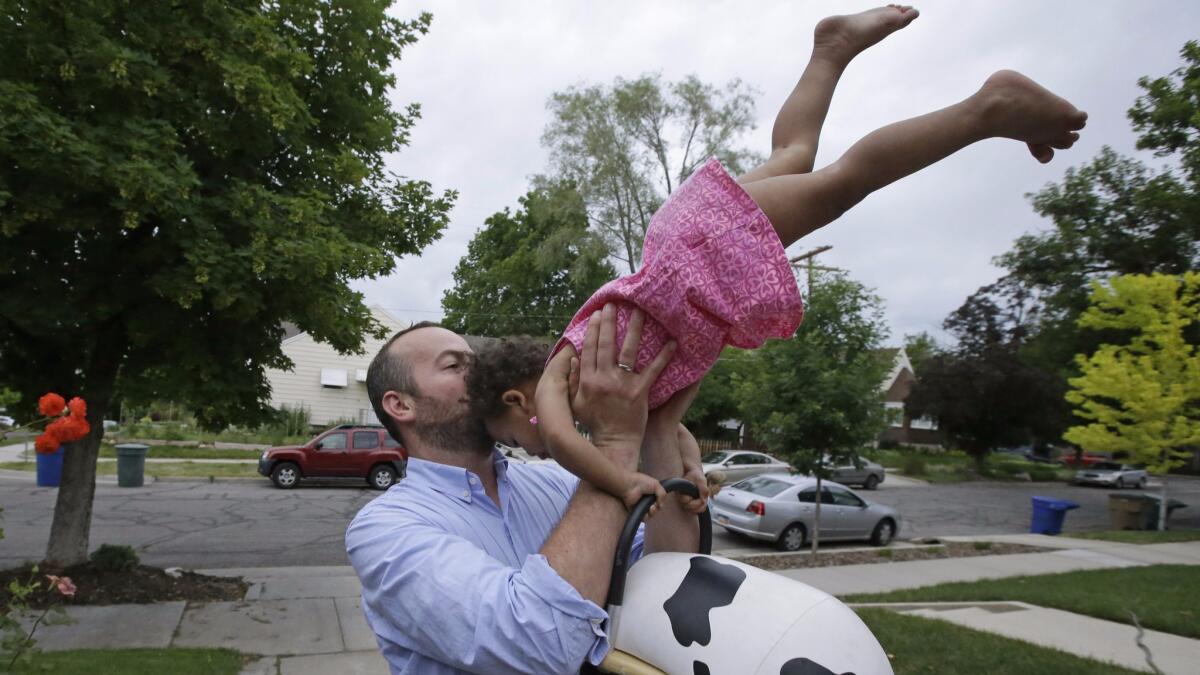 A father plays with his 17-month-old daughter outside their home in Salt Lake City in June 2015.
