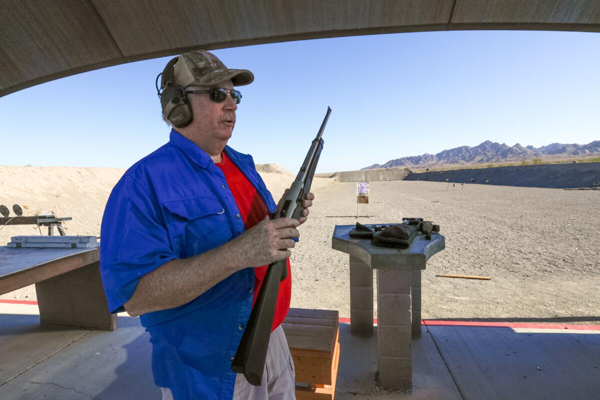 A man holds a rifle at a shooting club in Arizona.