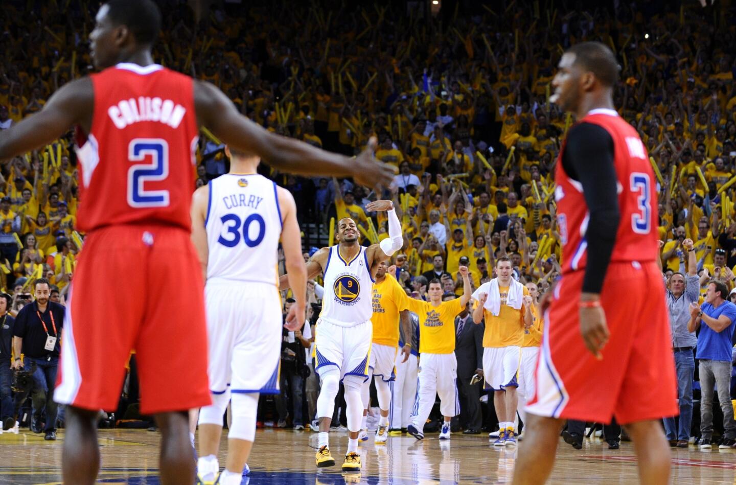 Warriors forward Andre Iguodala (background) and teammate Stephen Curry (30) celebrate in the final seconds while Clippers guard Darren Collison and Chris Paul (3) wonder why there was no foul call late in the game Thursdasy night.