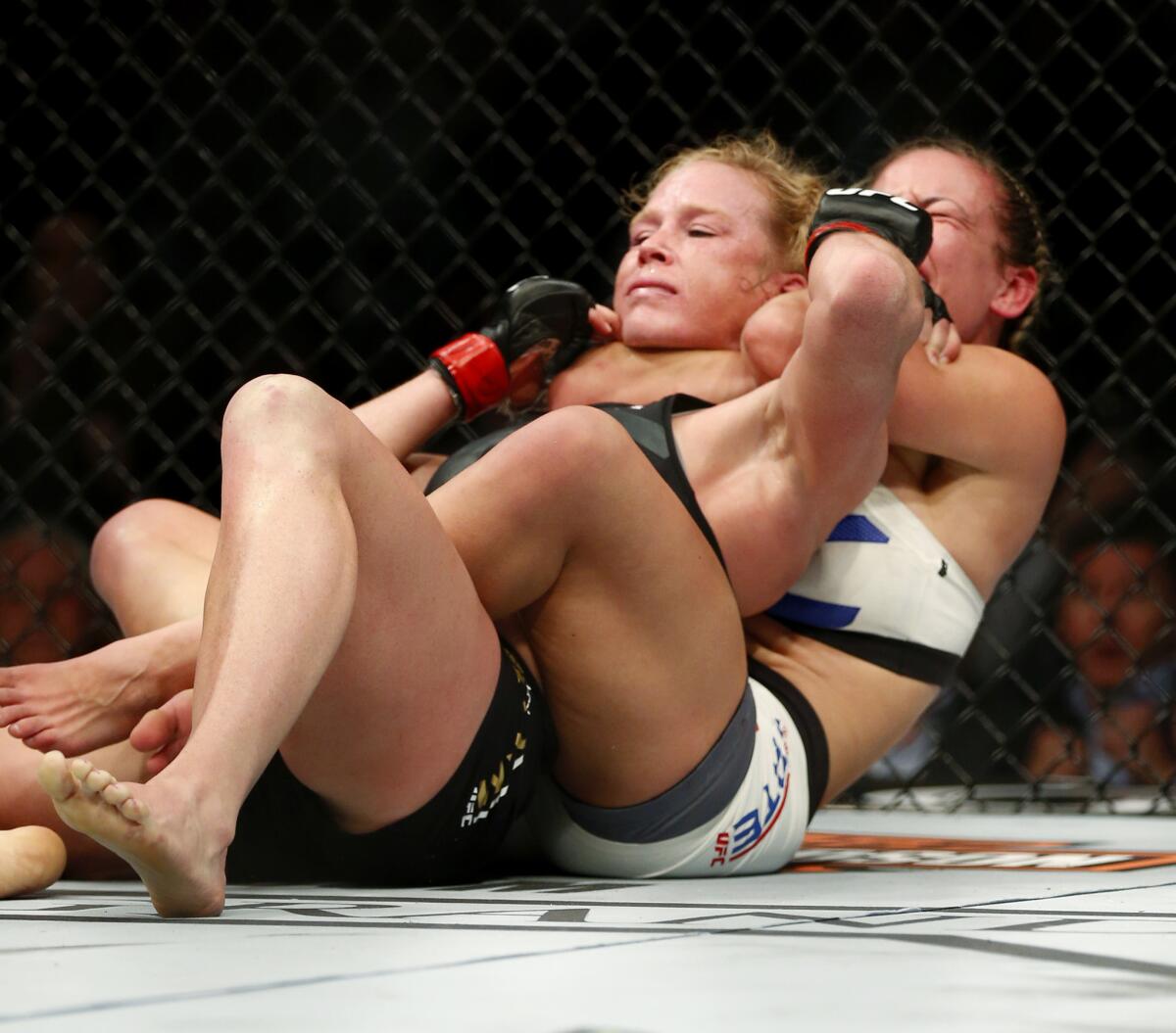 Miesha Tate, a la derecha, hace una llave de estrangulamiento sobre Holly Holm en su combate de artes marciales mixtas de UFC 196, el sábado 5 de marzo de 2016 en Las Vegas.