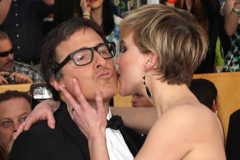 Jennifer Lawrence smooches "American Hustle" writer-director David O. Russell on the SAG Awards red carpet Saturday in Los Angeles.
