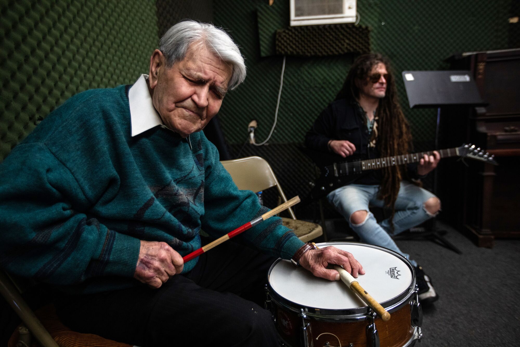 Jazz drummer Steve Hide, 91, left, is playing his drum in the studio with Leo Vaz, on guitar, right