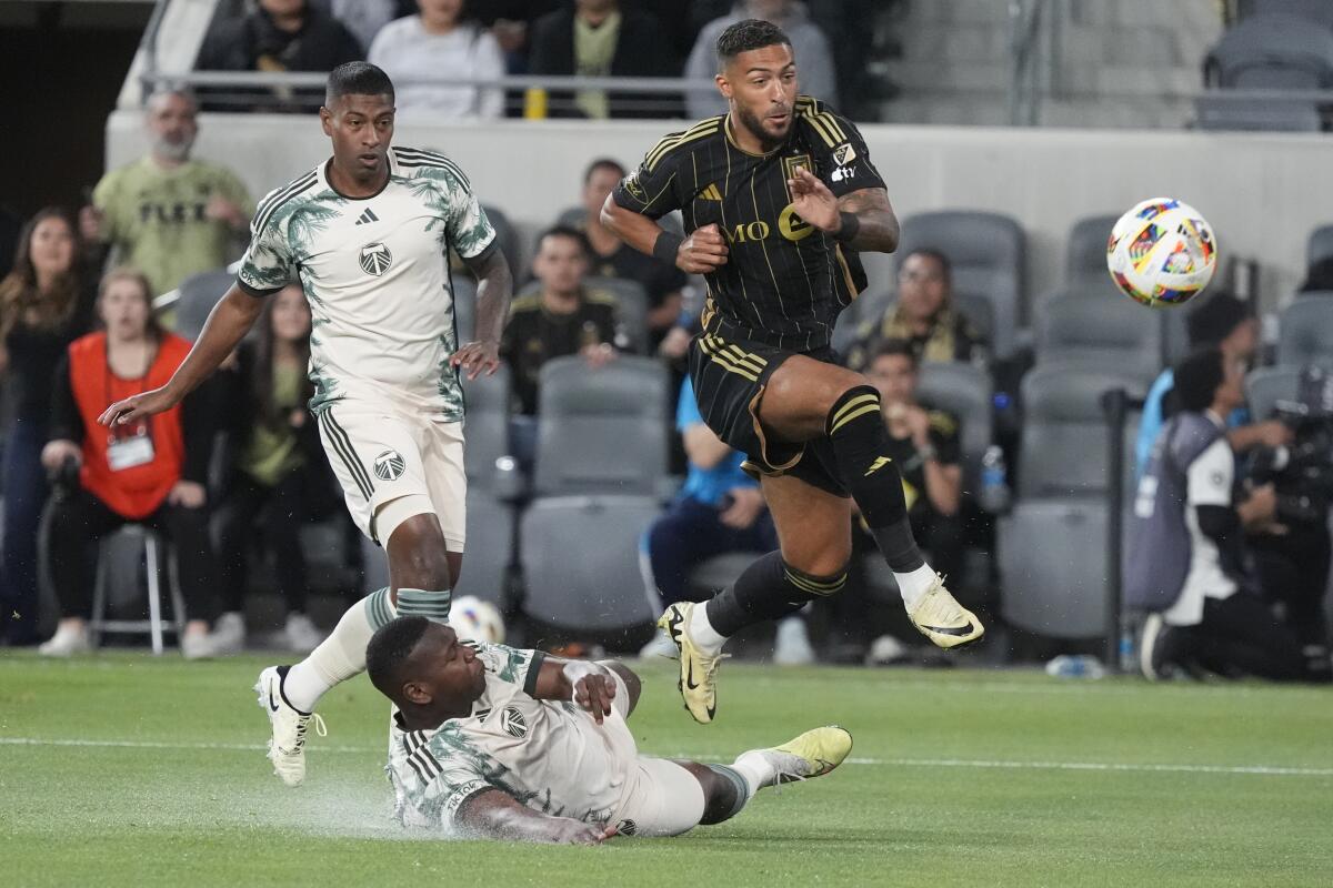 LAFC forward Denis Bouanga, top right, shoots over Portland Timbers defender Kamal Miller.