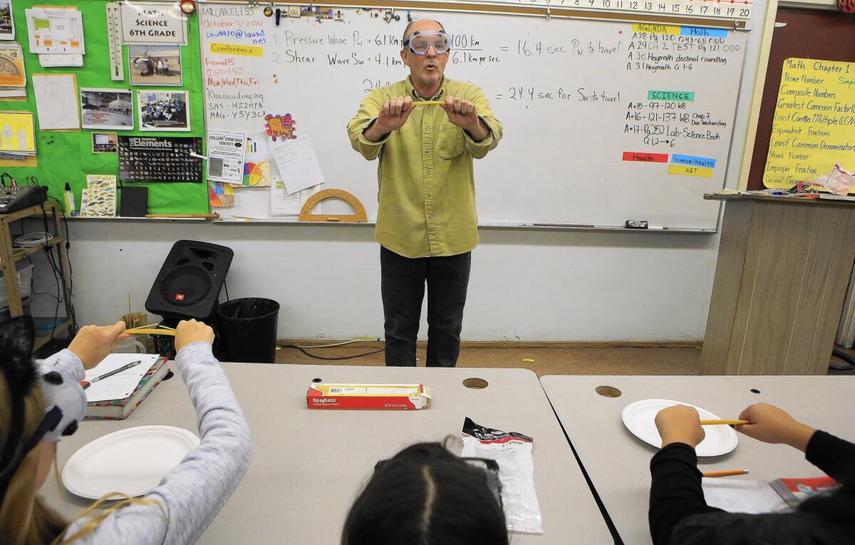 Charlie Unkeless, a math and science magnet teacher at John Burroughs Middle School, bends spaghetti in front of his sixth-graders to illustrate the elastic nature of the Earth's crust. Despite his love of teaching, Unkeless is so frustrated that he might soon give it up.