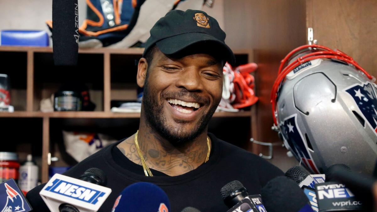 Green Bay Packers' Martellus Bennett, a former New England Patriots player, laughs as he speaks to media at his locker after NFL football practice Jan. 11, 2017, in Foxborough, Mass.