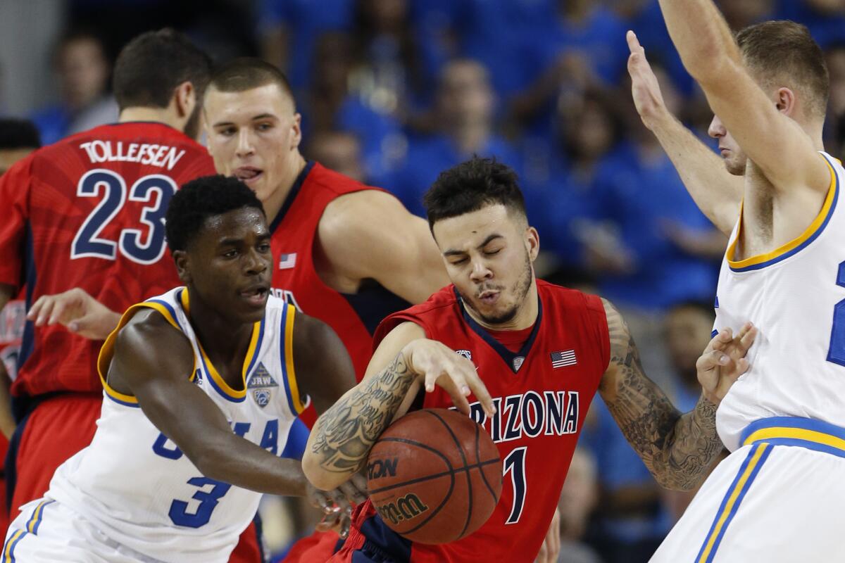 Arizona guard Gabe York struggles to split the defense of UCLA guards Aaron Holiday, left, and Bryce Alford during the second half.
