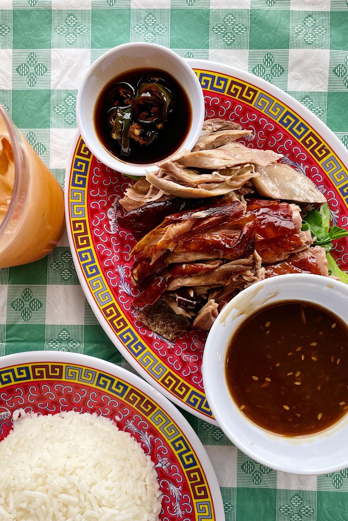A plate of sliced roast duck with sauce and rice.