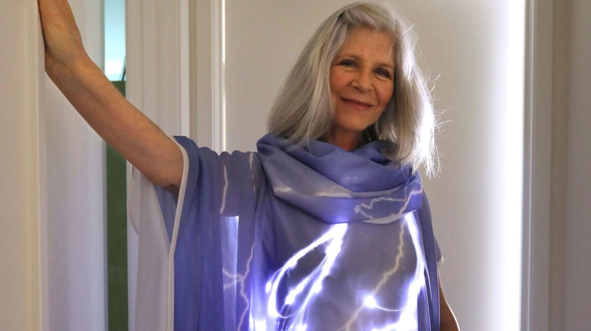 Rachel Merrill dressed in Lightning, a dress with four channels of light inside that create moving patterns of a lightning storm.