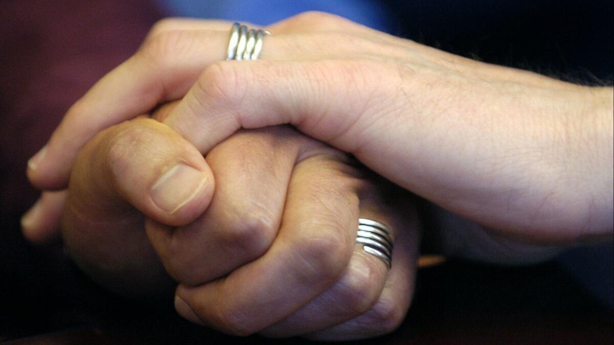 A couple displays their wedding bands.