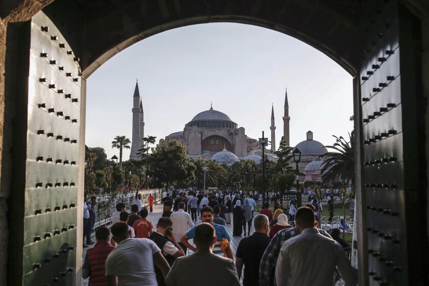 Turkish Muslims leave after Eid al-Fitr prayers at the city's landmark Sultan Ahmed Mosque, or Blue Mosque, in Istanbul, early Sunday, June 25, 2017. Eid al-Fitr marks the end of the Muslims' holy fasting month of Ramadan. Hagia Sophia Museum, another landmark of the city, is seen in the background. (AP Photo/Emrah Gurel)
