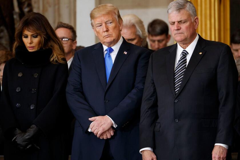 First lady Melania Trump, President Donald Trump, and Franklin Graham pray during a ceremony honoring Reverend Billy Graham in the Rotunda of the U.S. Capitol building, Wednesday, Feb. 28, 2018, in Washington. (AP Photo/Evan Vucci)