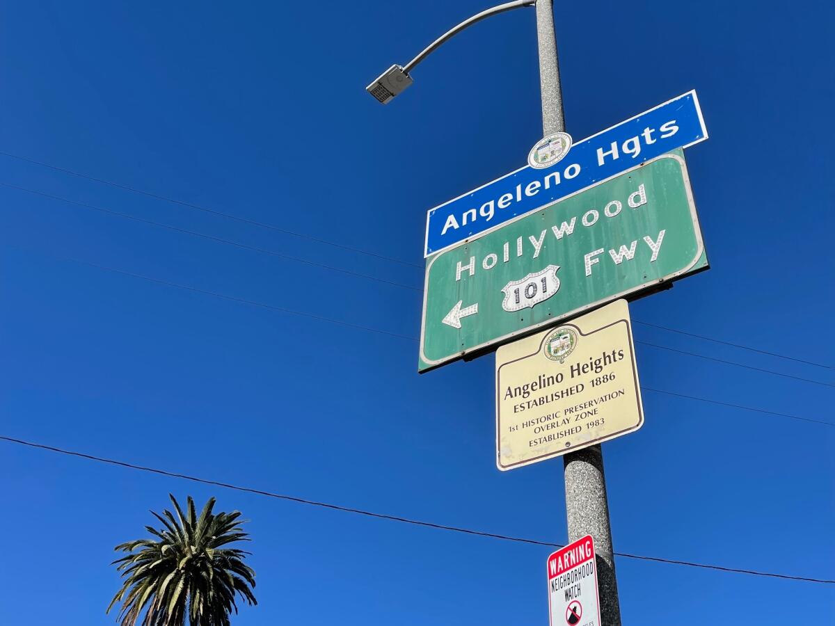 A blue city neighborhood sign spells out "Angeleno Hgts." The historic designator, however, spells it "Angelino Heights." 