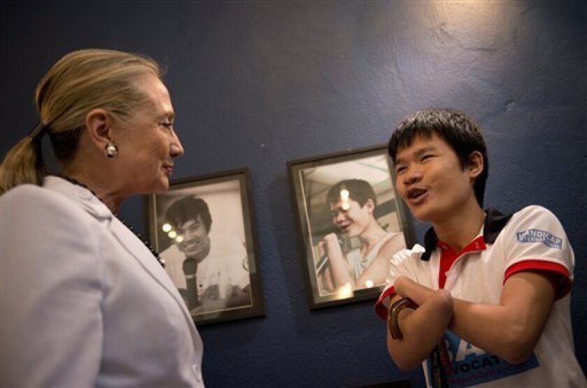 U.S. Secretary of State Hillary Rodham Clinton, left, greets Phongsavath Souliyalat, who lost his forearms and sight from a blast of an unexploded bomb left since Vietnam War while she tours the Cooperative Orthotic Prosthetic Enterprise Center (COPE), in Vientiane, Laos, July 11, 2012. COPE provides free prosthetics to those who need them including the victims of blasts of unexploded Vietnam War era ordnance, (AP Photo/Brendon Smialowski, Pool)