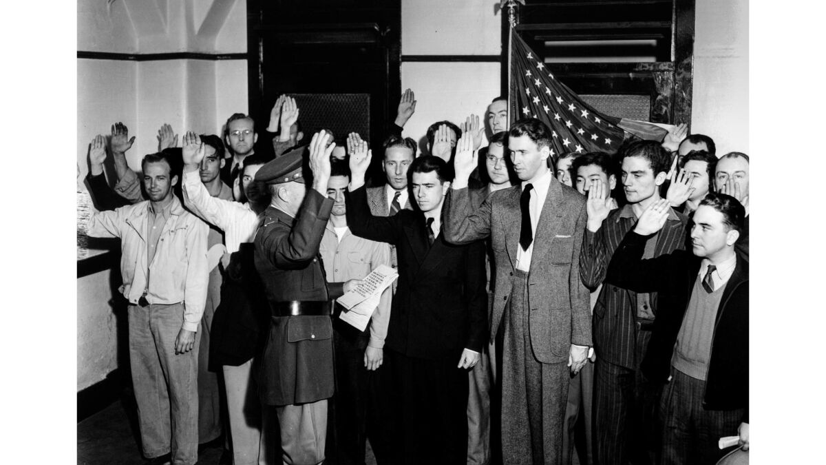 A group of men raise their right hand during an oath