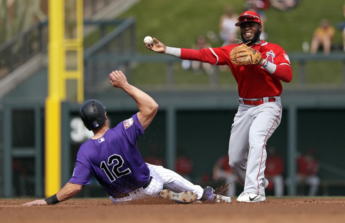 Angels second baseman Luis Rengifo, right, throws to first after forcing out Colorado's Mark Reynolds at second during a spring training game in March.