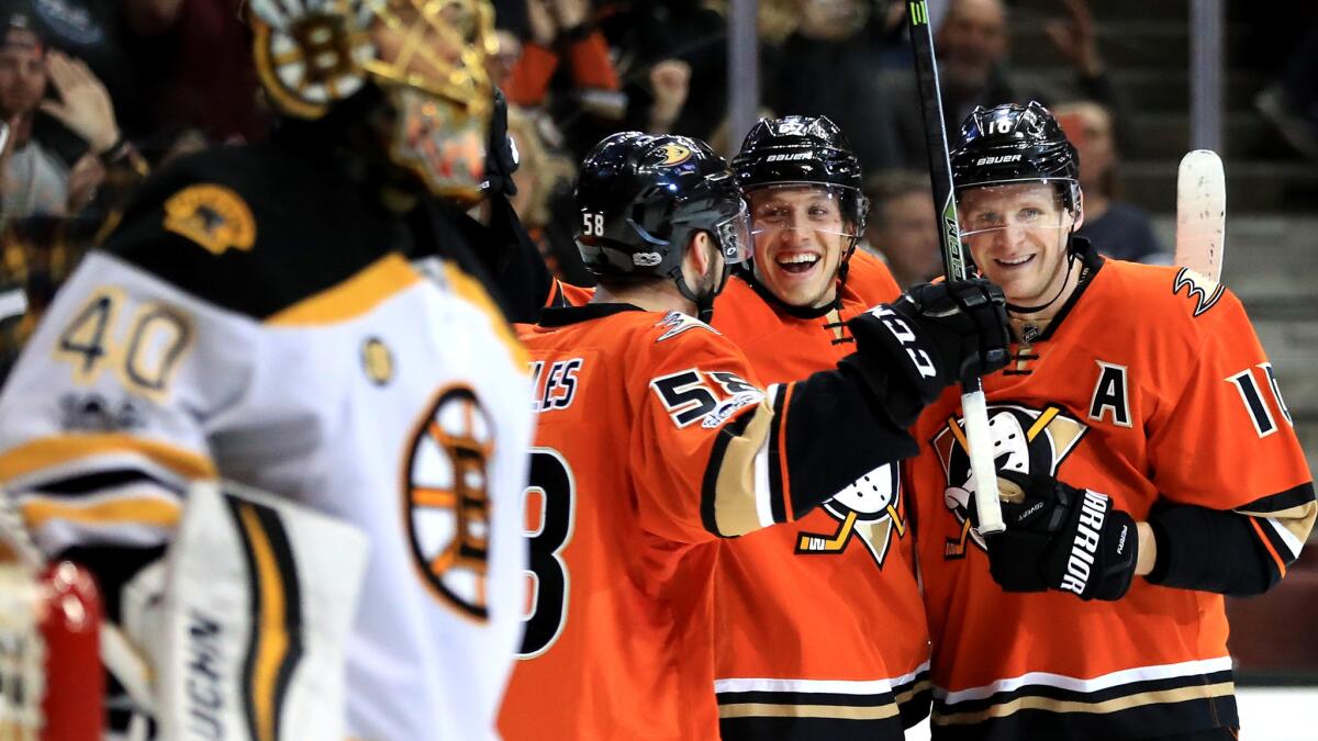 Ducks center Rickard Rakell (center) is congratulated by teammates Corey Perry (10) and Nicolas Kerdiles (58) after scoring against the Bruins and goalie Tuukka Rask (40) during the third period Wednesday.
