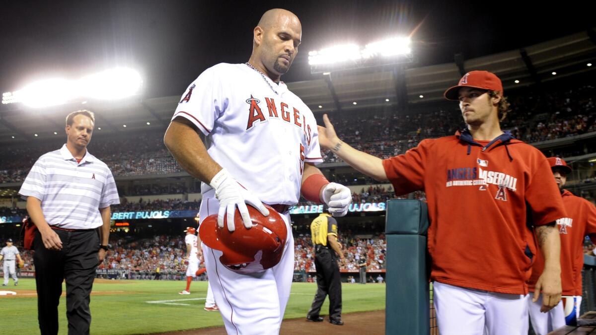 Angels first baseman Albert Pujols walks off the field after suffering a cramp in his left leg during Monday's game against the Seattle Mariners.