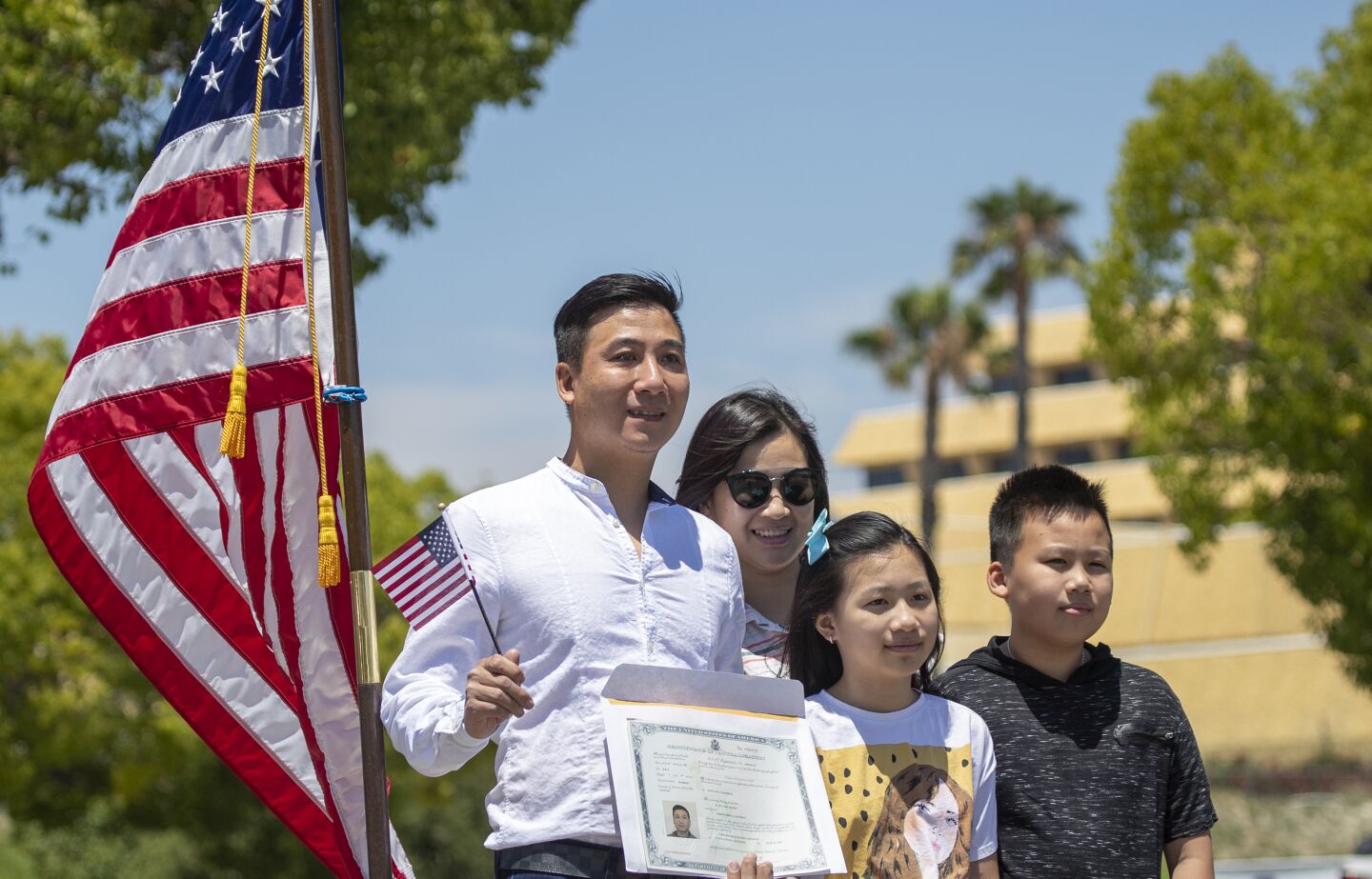 Tuyen Nguyen, who immigrated to Garden Grove from Vietnam, takes a celebatory photo with his wife, Chi Tran, and children.