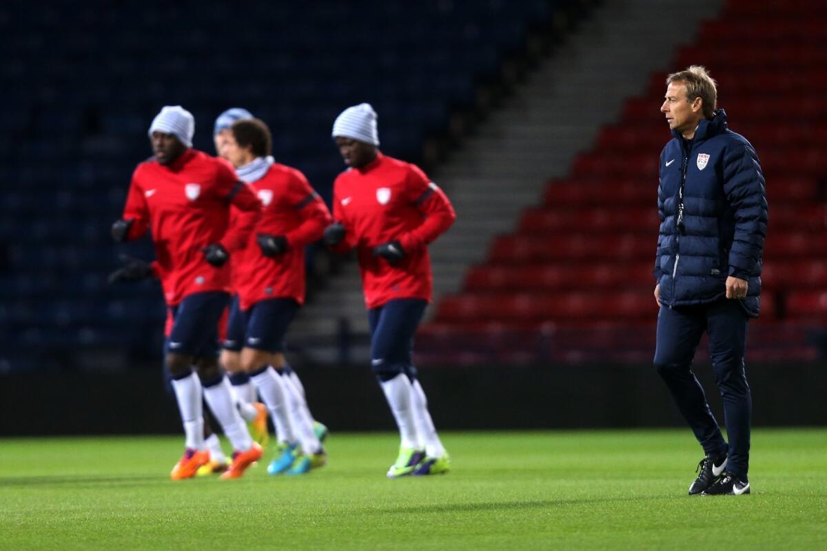 U.S. Coach Juergen Klinsmann, right, looks on at his squad during a team training session in Glasgow, Scotland, on Nov. 14.