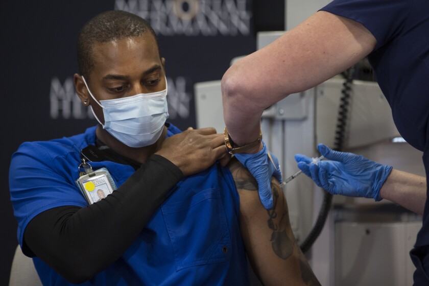 Robert Luckey, COVID ICU Nurse, receives Texas Medical Center's first dose of the Pfizer-BioNTech vaccine.