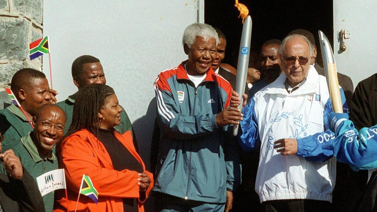 Ahmed Kathrada (on right) and former South African President Nelson Mandela hold Olympic torch in 2004.