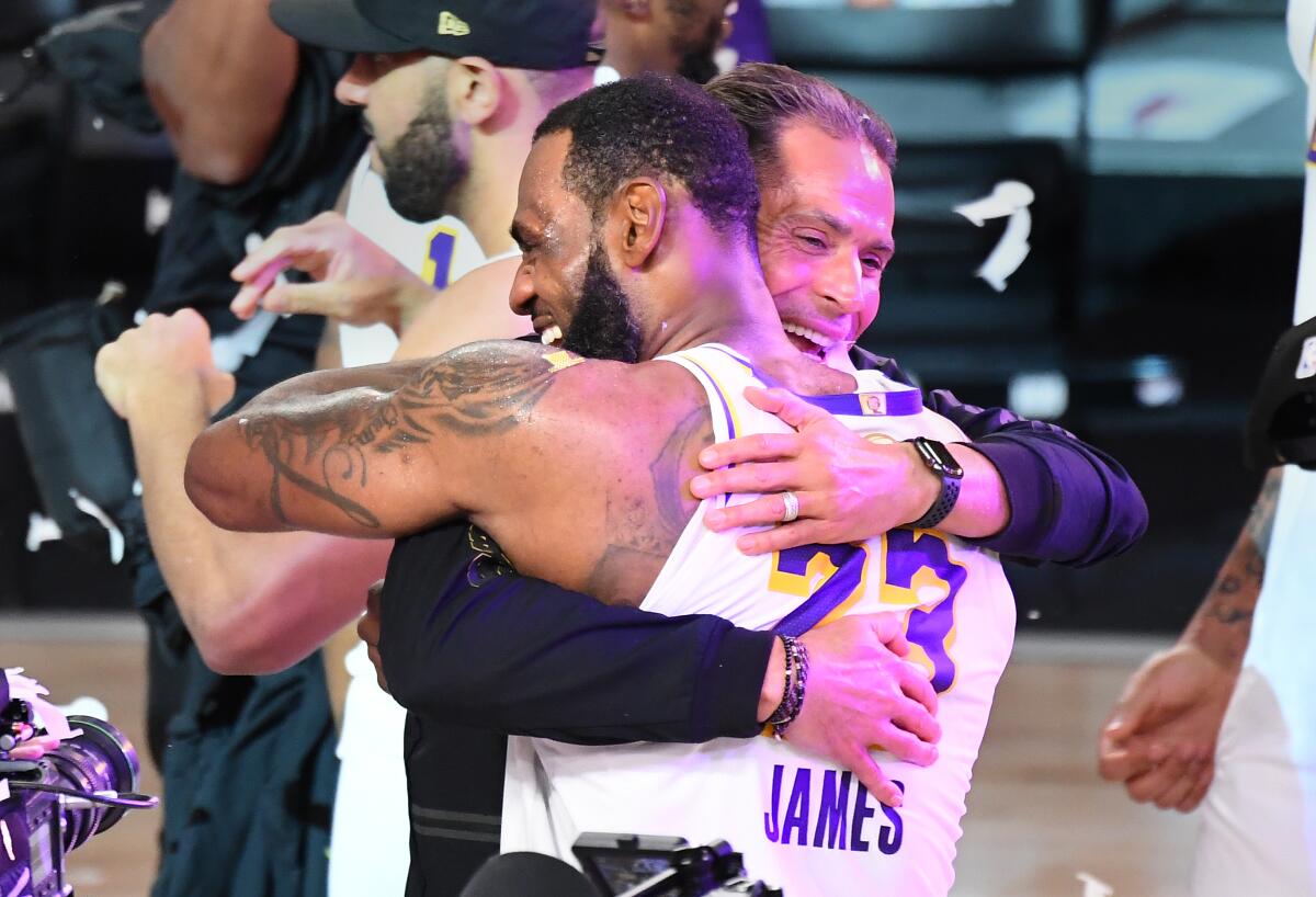 Lakers star LeBron James hugs general manager Rob Pelinka after defeating the Miami Heat for the NBA title in October.
